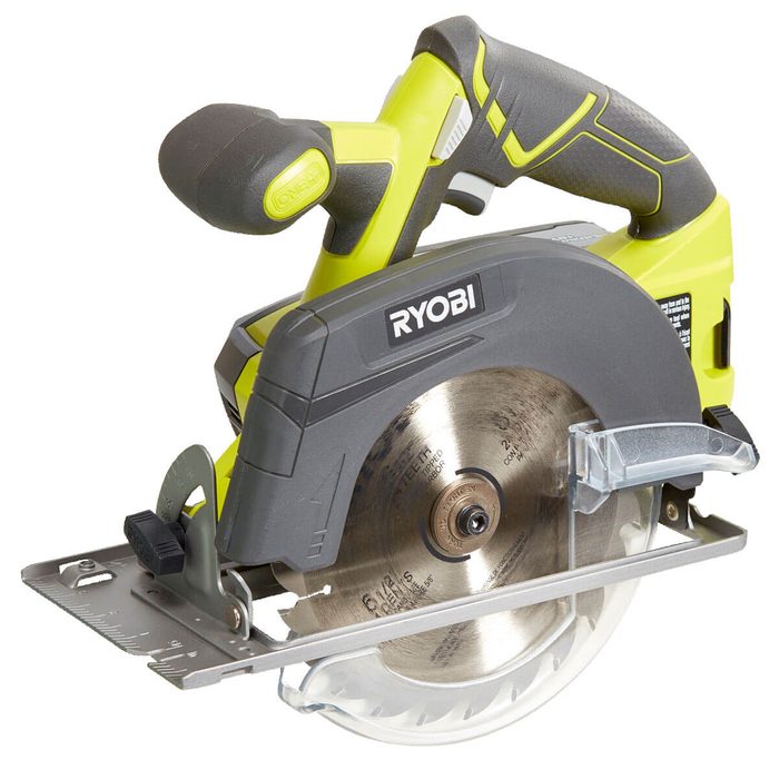 A circular saw with a black and yellow handle is positioned for cutting, featuring a silver blade and a guide for precise measurements.