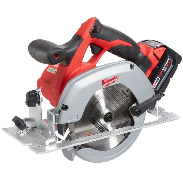 A red and silver circular saw sits, ready for use, with a blade positioned for cutting, surrounded by a minimalist workshop backdrop.