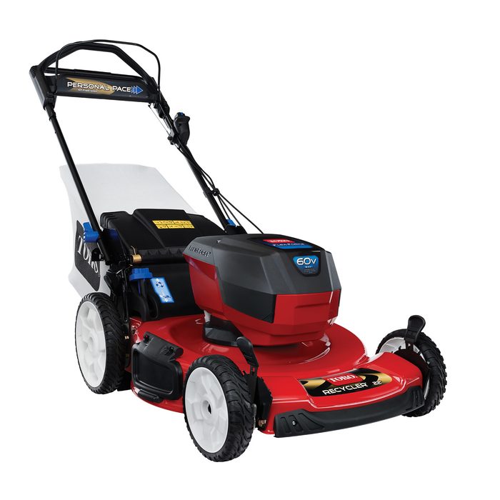 A red lawn mower stands still, featuring a battery compartment and large wheels, designed for mowing grass in residential yards.