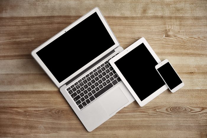 Devices with blank screens on wooden background, top view. Mock up for design