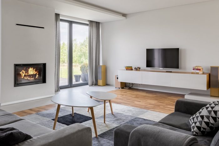 Panoramic view of luxurious living room with fireplace, tv and two couches