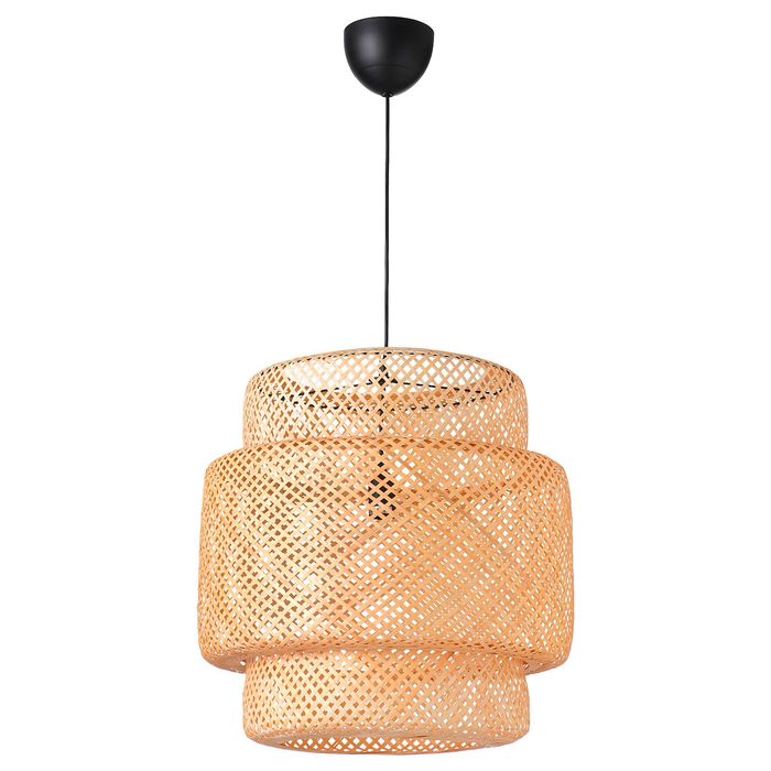 A woven pendant lamp hangs from the ceiling, radiating light through its intricate, layered design in a neutral space.