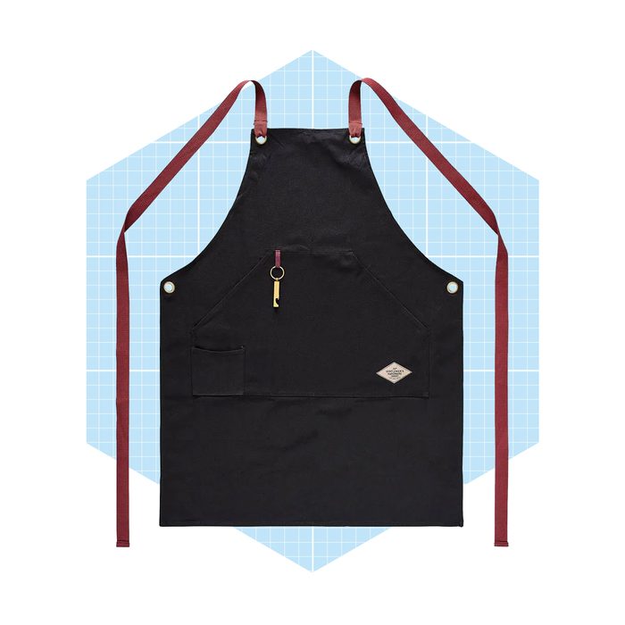 A black apron hangs with maroon straps and a golden keychain, set against a light blue geometric background.