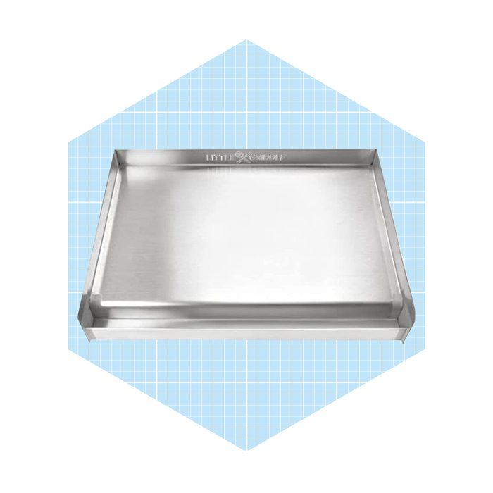 A stainless steel baking tray rests on a light blue grid-patterned background, ready for use in cooking or baking tasks.