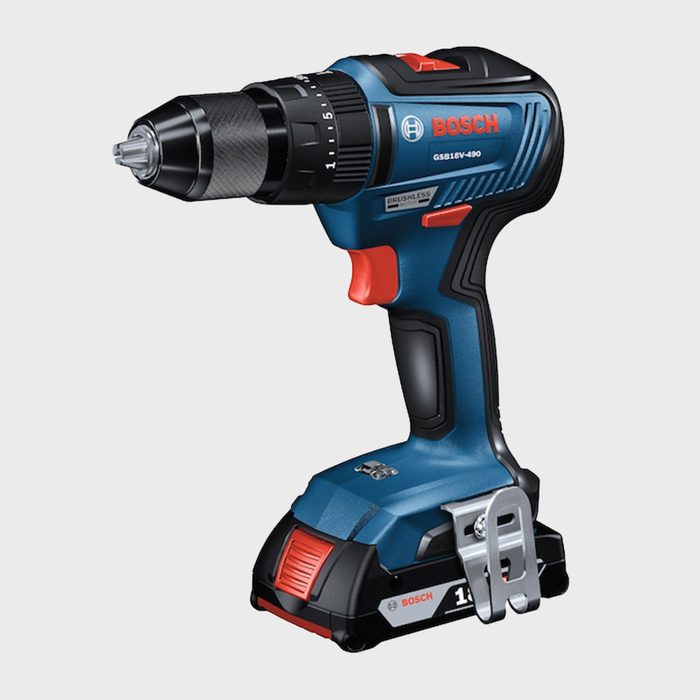 A blue and black cordless drill is positioned upright, featuring a rotating chuck for drill bits, with a red trigger and battery pack attached.