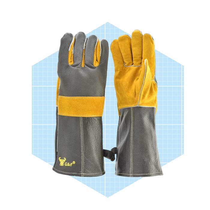 A pair of leather work gloves stands upright, showcasing a combination of dark gray and yellow materials, set against a light blue grid background.