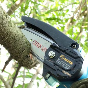 A chainsaw cuts through a tree branch, surrounded by green foliage, indicating a gardening or landscaping activity in a natural environment.