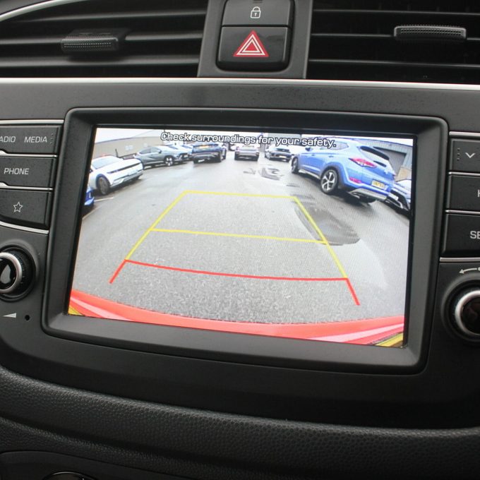 Car dashboard backup camera with three lines overlaid on the video feed